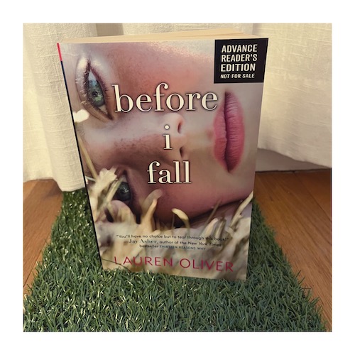 Jen's very first advance reader copy was Before I Fall by Lauren Oliver. Teh ARC is pictured on some fake grass in front of a linen curtain.