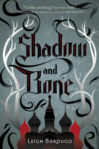 The cover of Shadow and Bone by Leigh Bardugo has a grey background, decorative antlers, and illustrated Russian skyline.