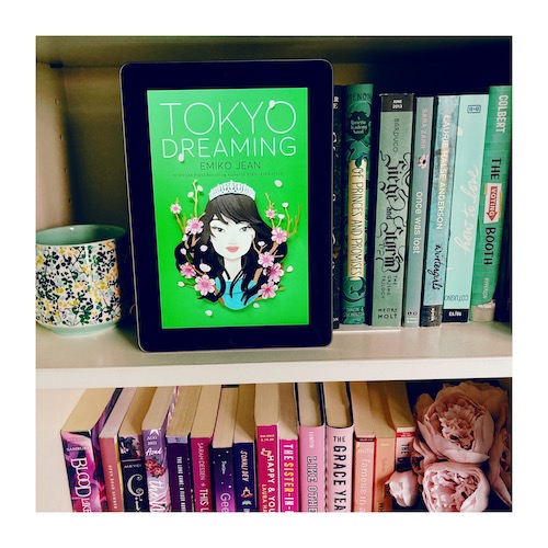 Original photo of a copy of Tokyo Dreaming on a bookshelf with other green and pink YA books.