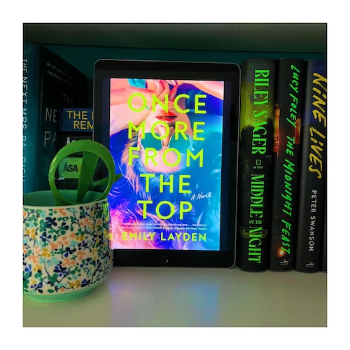 Original photo of a copy of Once From the Top on a shelf with a green and blue mug. The book's cover features a woman in sunglasses lying on her back.