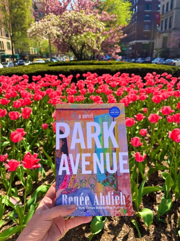 Orginal photo of a hand holding a copy of Park Avenue in front of the Park Avenue median planted with red tulips
