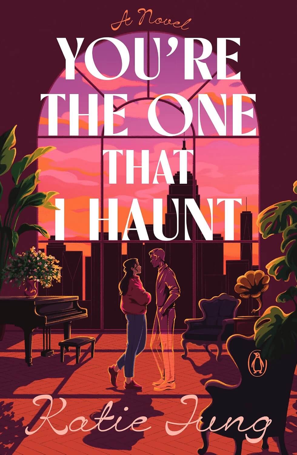 Cover of You're the One That I Haunt, which shows a view of a NYC sunset from inside an apartment.